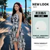 Maiô de peça única de alta qualidade, com estampa floral vintage e efeito de lavagem com tinta, apresentando um delicado decote halter e um design de saia assimétrico para uma silhueta favorecedora.