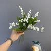 Pequeñas orquídeas campana frescas de simulación, campanillas azules, flores falsas, novia sosteniendo flores, flores de boda