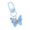 Llavero de resina de mariposa en colores de caramelo con un delicado colgante floral, llavero de cuentas DIY para el corazón de las niñas, accesorio a juego