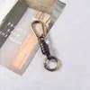 Tablero de accesorios para llaveros tejido a mano de fábrica hebilla de botón cadena de llave de cuerda de cuero versátil retro semiacabado para colgar DIY