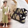 Sandalias para niños 2025 verano estilo coreano para niñas con tira cruzada princesa sandalias de una palabra moda para niños medianos y grandes zapatos individuales de rendimiento