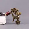 Llavero Colgante Sanxingdui de Latón con Figura Humana Grande de Cobre, Sacerdote Orante, Máscara de Ojos Verticales y Pájaro Divino