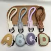 Venta al por mayor transfronteriza de llaveros japoneses y coreanos con letras en inglés, dijes para bolso de cuero dopamina, pequeños accesorios y regalos