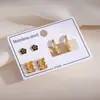 Pendientes de botón de flor de cinco pétalos en negro y dorado estilo europeo para mujer Juego de tres piezas Sensación de alta gama Acero inoxidable con incrustaciones de oro y pedrería Pendiente de aro redondo