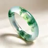 Pulseras de jade de gran venta con patrones florales azules naturales, translucidez similar al hielo y colores vibrantes, perfectas para que las mujeres las usen en un estilo tradicional chino.. Disponible al por mayor