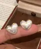 Aretes de puntos blancos sobre fondo blanco lechoso en forma de corazón para mujer, delicados y juveniles, realzan el temperamento y la vitalidad, versátiles y fáciles de combinar, exudando sin esfuerzo un ambiente juvenil.