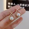 Exquisitos pendientes pequeños de diamante dulce Pendientes de perla con cruz coreana Pendientes de diseño simple de nicho para mujer Venta al por mayor