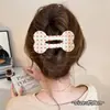 Um grampo de cabelo estiloso e versátil para mulheres, apresentando um design de bico de pato que não pressiona a parte de trás da cabeça, perfeito para criar penteados elegantes no outono e inverno.