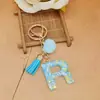 Nuevo diseño transfronterizo: llavero de letra brillante con lentejuelas, con un pompón rosa y borla, perfecto para bolsos de niñas y como colgante para llaves