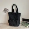 Bolsa tote de nailon minimalista casual de nicho estilo coreano con diseño único, gran capacidad, alto atractivo estético y diseño de cordón, adecuada para llevar en la mano o al hombro.