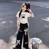 Verão 2026 Novo Conjunto de Duas Peças Fofo e Doce: Camiseta de Manga Curta com Gatinho Desenho Animado, Renda com Laço, Calça de Barra Reta