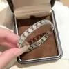 Pulsera Cruzada de Cuatro Hojas Hueca Más Vendida para Mujer Exquisita Hebilla Incrustada de Circonita Material de Latón Amarillo Joyería de Mano Versátil