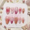 Arte de unhas floral delicada e translúcida em tom rosa nude, com estilo de fada, apresentando um relevo tridimensional de estrela-do-mar e detalhes dourados, pontas em formato amendoado.