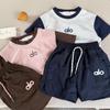 Traje infantil 2025 guiñando verano nuevo niños y niñas contraste de color letra traje bebé manga corta conjunto de dos piezas moda