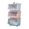 Caixa organizadora de plástico com tampa articulada para brinquedos, roupas e lanches infantis. Caixa organizadora transparente com abertura frontal e boca inclinada.