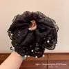 Elegante y grácil scrunchie de encaje y perlas con malla rizada para un look suave y etéreo en la parte posterior de la cabeza