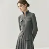Colección Otoño/Invierno 2026 de Bai Cai Rong: Cárdigan de punto estilo europeo con cuello alto y cremallera, una prenda exterior a rayas de alta gama y a la moda