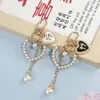 Llavero Colgante Forma de Corazón con Lazo y Perlas Estilo Chanel para Funda de Teléfono Bolso Encanto Regalo Pequeño Accesorios DIY