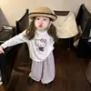 Nueva colección de otoño para niñas: un top divertido y juguetón de manga larga con estampados de dibujos animados, combinado con elegantes y versátiles pantalones de cuadros de pierna ancha