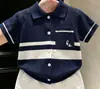 Ropa infantil coreana 2026 verano nuevo estilo azul marino calado cuello polo manga corta tejido y pantalones cortos blancos infantiles modernos