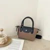 Bolsas de pano Oxford com blocos de cor simples transfronteiriças Bolsa de bolinho Xiangjiao bolsa de mão versátil de nicho bolsa de ombro com textura da moda