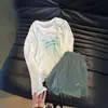 Camiseta branca de manga longa estilo americano com proteção solar para mulheres, nova coleção de verão 2026, saída de praia leve com proteção solar, top de corte solto e modelador