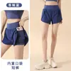 Pantalones cortos deportivos falsos de dos piezas anti-exposición para mujer con bolsillos laterales, holgados de cintura alta, levantamiento de glúteos, para correr, fitness y yoga