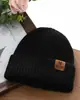 Novo Chapéu de Lã Tricotado com Etiqueta de Couro de Letra para Outono e Inverno, Chapéu de Moda Versátil para Exterior à Prova de Frio para Mulheres, Camada Dupla Quente