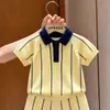 Ropa infantil coreana 2026 verano nuevo conjunto de punto a rayas amarillas camisa de punto de manga corta con cuello Polo y pantalones cortos para niños