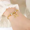 Pulsera de moda personalizada estilo oro europeo y americano 26 letras Incrustada de diamantes Lujo ligero Acero de titanio no descolorante Chapado en oro de 18 quilates Pulsera