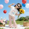 Ropa Infantil Coreana 2026 Verano Nuevo Estilo Tops de Manga Corta para Niñas y Pantalones de Campana Color Sólido Elástico Casual Dulce Conjunto de Dos Piezas