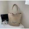 Bolsa de mano tipo tote simple de estilo coreano al por mayor para mujer 2025 Verano Nuevo Gran Capacidad Hombro Único Lona Versátil Bolso de Axila