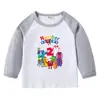 2026 Nova Camiseta Infantil Transfronteiriça Primavera e Outono Gola Redonda Desenho Animado Manga Longa Camisa Básica para Meninos e Meninas Camiseta de Algodão para Bebê
