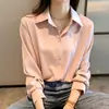 Camisa feminina de chifon para o início da primavera de 2026, top com design moderno, corte solto, usada em camadas com camisa branca como base.