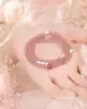 O Pingente Pérola Rosa é uma pulseira de pérolas de três fios para mulheres feita de cristal branco e cristal de morango