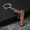 Llavero con forma de pistola, colgante de arma de fuego de aleación vintage, accesorio para bolso de hombre, merchandising de juegos, venta al por mayor de pequeños regalos