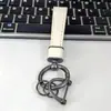 Exquisito Colgante Llavero de Cuero para Coche Accesorio de Bolso, Parche de Cuero Personalizado y de Moda Blanco y Negro Llavero de Nicho al por Mayor