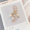 Llavero colgante de aleación creativa con forma de corazón, perla y concha, accesorios para bolso, adornos de joyería metálica, regalos pequeños al por mayor