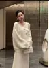 Conjunto de duas peças em tricô floral tridimensional, macio e delicado, estilo francês, com saia afunilada, na cor off-white com pedrarias