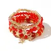 Pulseras multicapa al por mayor, juego de cuatro piezas de joyería con cuentas de artesanía en vidrio, juego de pulseras elásticas, accesorio de mano con soporte de flor de hierro