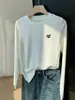 Camiseta de manga larga de nicho, de alta gama, con dobladillo curvo, moderna y elegante, efecto adelgazante, top base para el otoño de 2026
