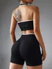 Novo conjunto esportivo feminino de duas peças sem costura com gola halter e acabamento branco, incluindo um sutiã sem costas e shorts de ciclismo de cintura alta que levantam o bumbum