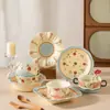Cuenco de arroz de cerámica para uso doméstico, modelo nuevo con patrón de fresas en relieve lindo, alto valor estético, color bajo vidriado, juego de cuenco y plato para una persona