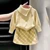 Novedad de otoño 2026 para niñas estilo coreano: conjunto de dos piezas para niñas pequeñas: suéter de punto color amarillo crema con cuello y falda de cuadros