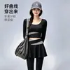 Conjunto de yoga de dos piezas de alta gama en bloques de color para mujer, cuello redondo, top corto de manga larga, cintura cruzada, pantalón falda de dos piezas falsas, deportivo