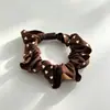 Goma para el pelo floral en forma de corazón, con un suave y texturizado tejido de satén en una paleta de colores apagados, con delicados detalles de encaje plisado para un look suave y refinado