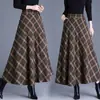Foto real de la nueva falda de lana a cuadros de longitud media para otoño e invierno 2026, corte ajustado, cintura alta, falda de línea A con dobladillo ancho