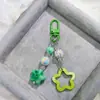 Hebilla de puerta G05 nuevo acrílico hueco brillante estrella de cinco puntas llavero para coche colgante crema dos colores campanilla a juego