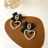 Pendientes de perla con forma de corazón negro y lazo, estilo otoño/invierno transfronterizo, pendientes de nuevo estilo, retro y elegantes, con un toque de alta gama, pendientes estilo Hong Kong
