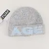 Gorro de mezcla de lana de alta calidad para estudiantes, perfecto para otoño e invierno, hace que la cara se vea más pequeña, presenta un patrón de jacquard con letras y es un gorro ajustado y ceñido.
